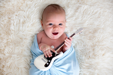 bebe qui joue de la musique avec un grand sourire