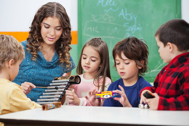 professeur de musique explique le xylophone à des enfants de maternelle