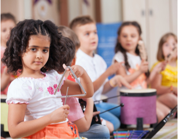 Enfant jouant du triangle dans un cours d'éveil musical