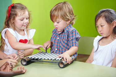 petit garçon à l'âge de 2 ans jouant du xylophone pour son éveil musical