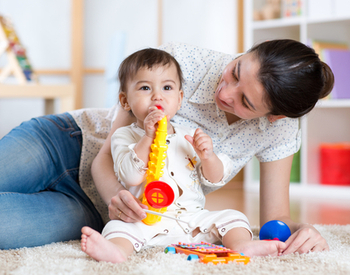 bébé musicien avec jouet musical saxophone en compagnie de sa maman à la maison