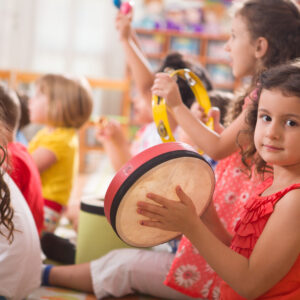 Enfant de 4 ans jouant du tambourin dans un groupe de musique