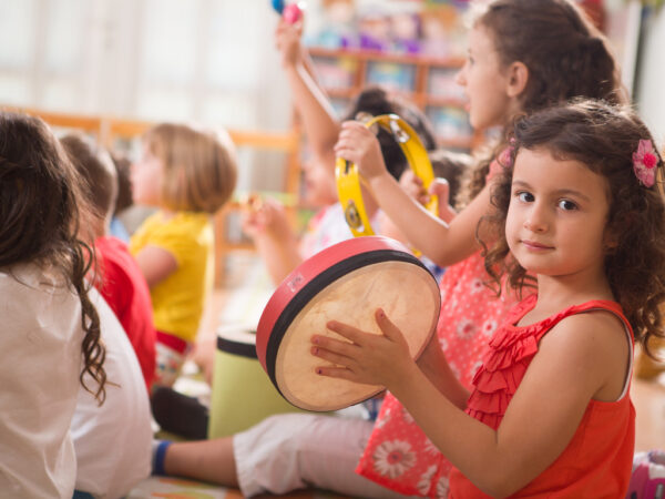 Enfant de 4 ans jouant du tambourin dans un groupe de musique