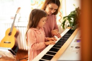 Parent encourageant son enfant pour enseigner la musique le piano la guitare