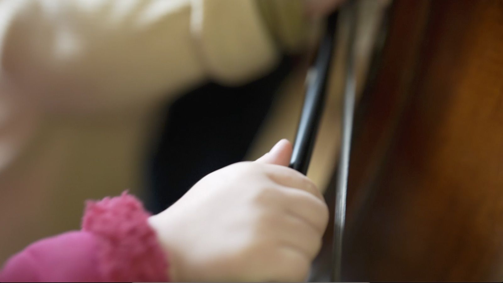 Enfant tenant l’archet d’une contrebasse pendant un atelier d’éveil musical